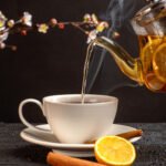 front-view-cup-tea-with-lemon-cinnamon-kettle-grey-desk